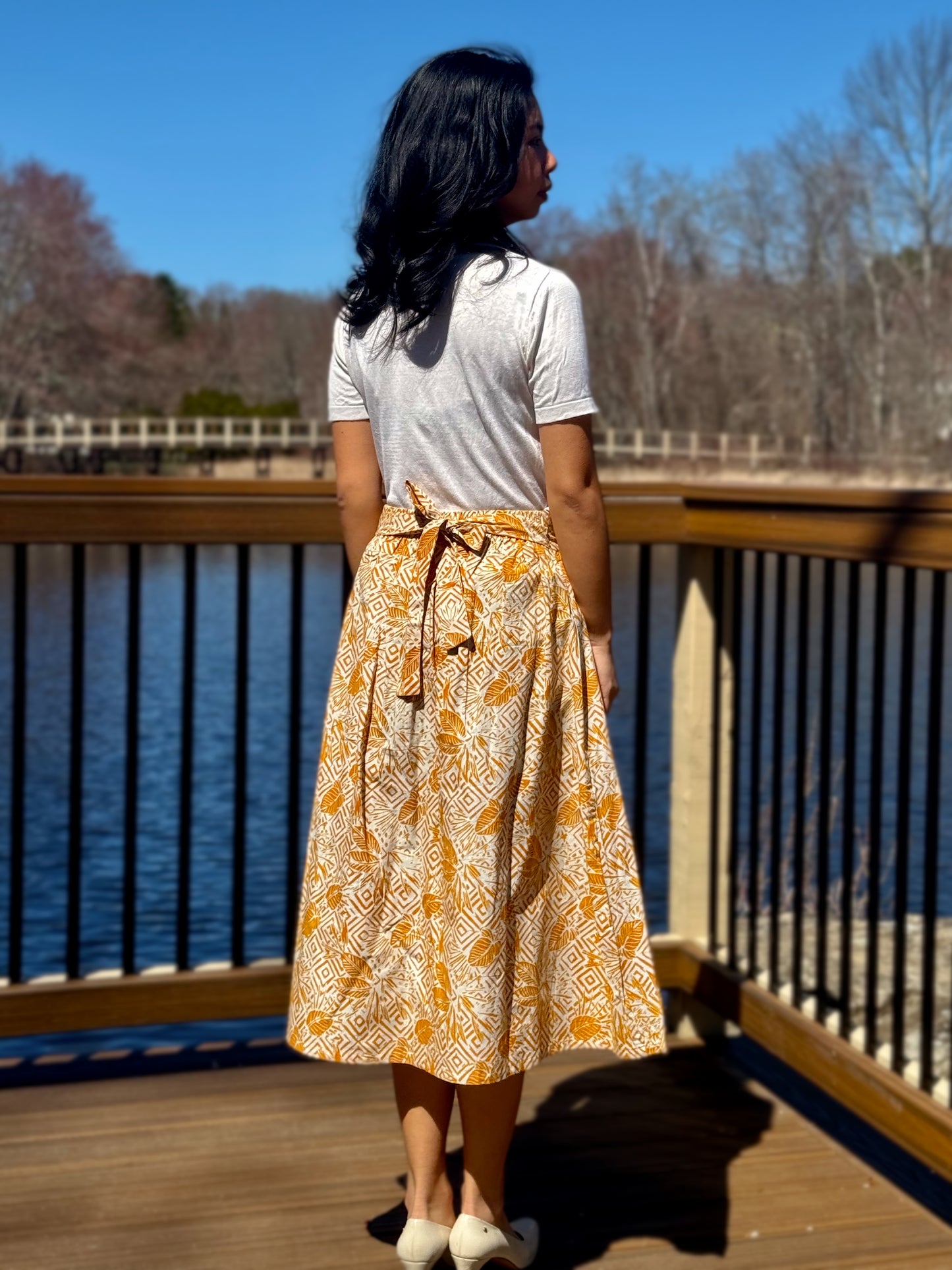 Back view of Taylor A-line skirt in Yellow with waist tie, tied as bowtie.