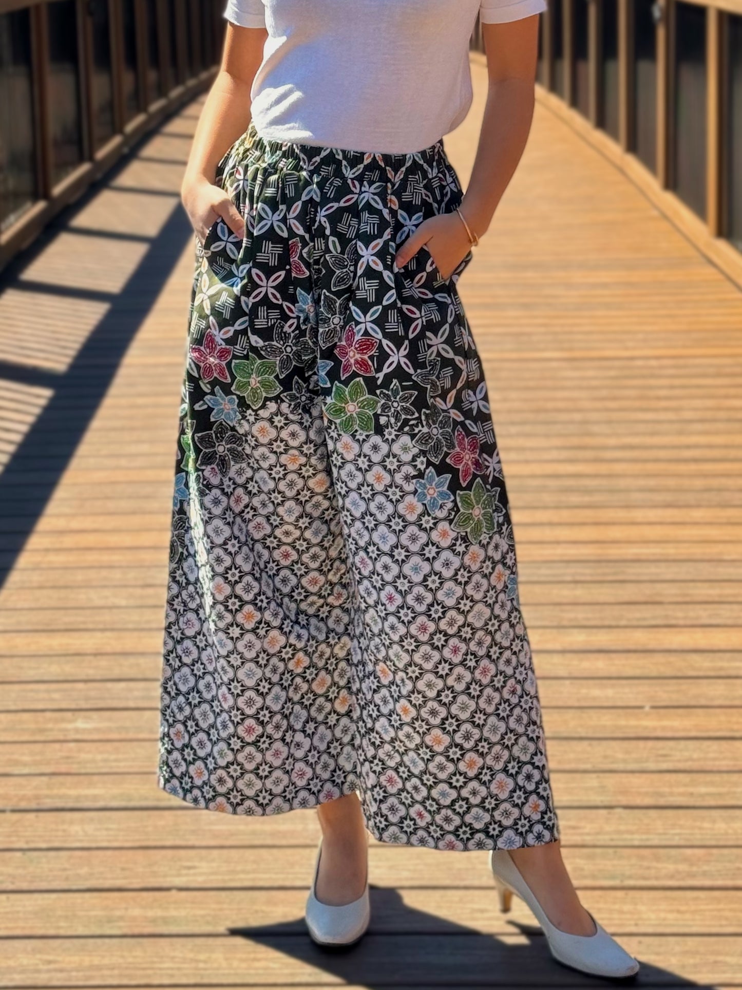 Close up view of dark green Nami barrel pants with flower pattern.
