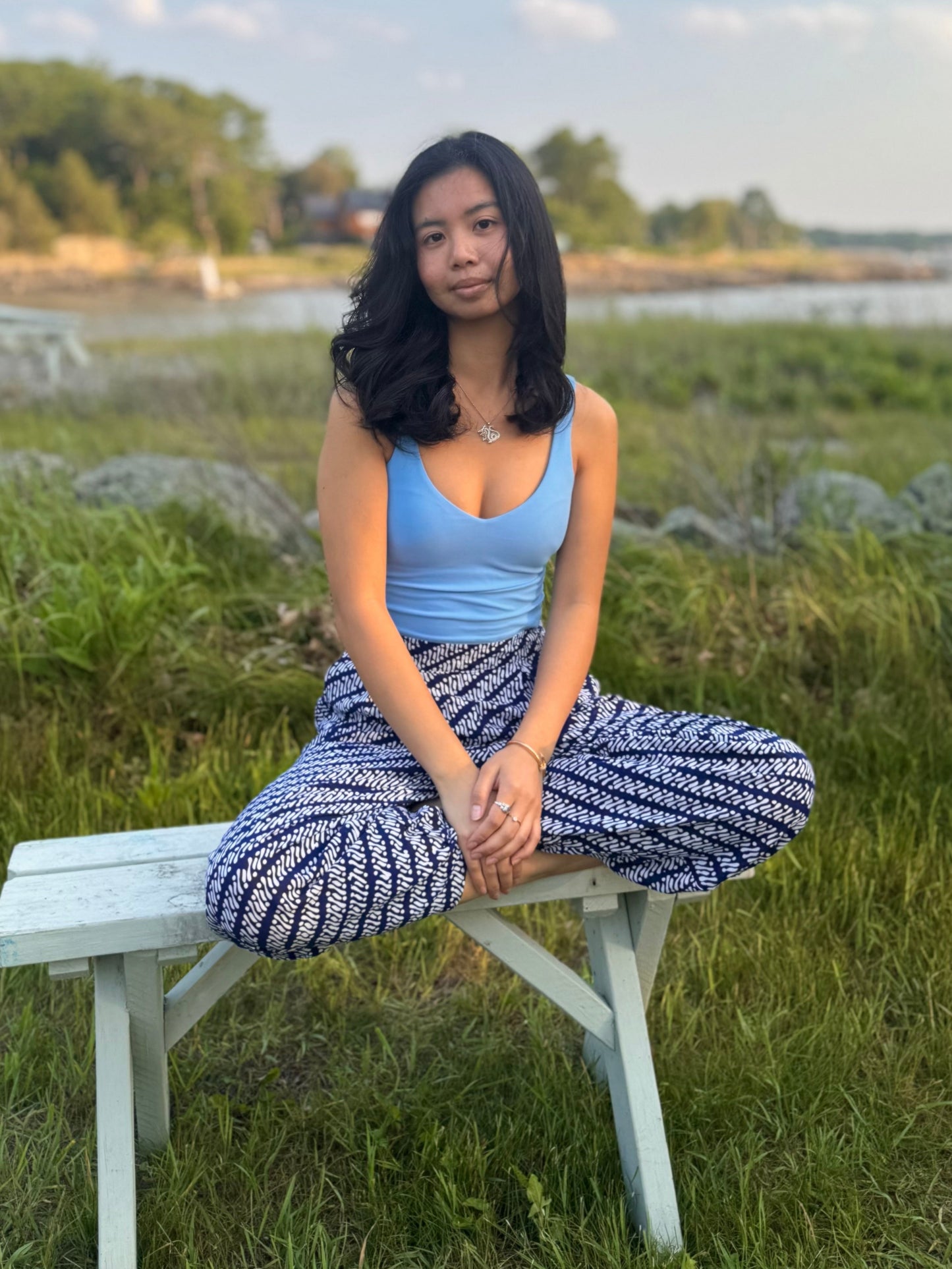 Model sitting criss-crossed wearing dewi yoga pants in black