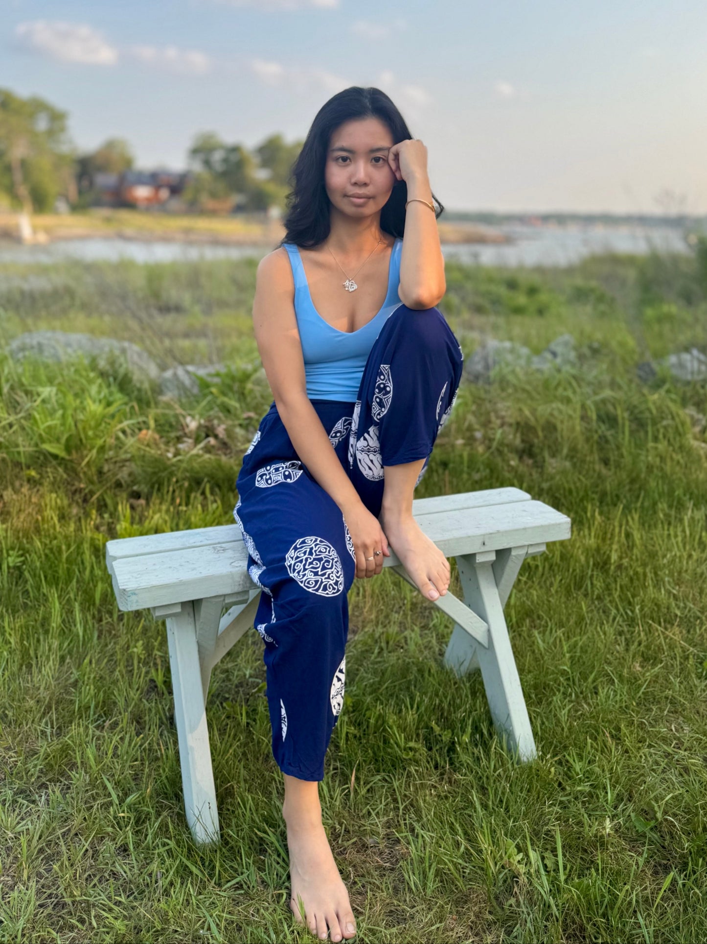 Model wearing navy dewi yoga pants sitting on a bench.
