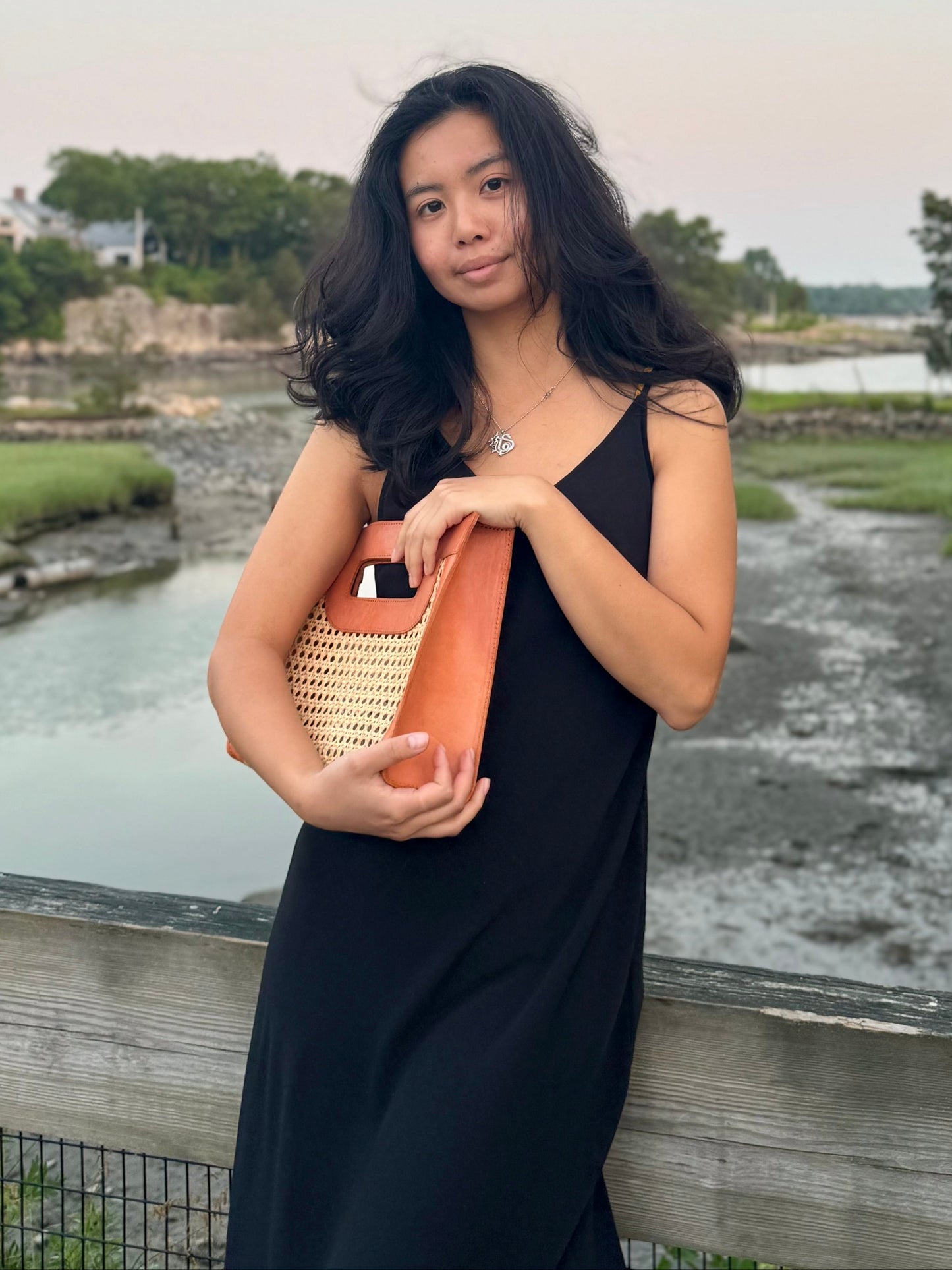 Model hugging the Fitri rattan cane clutch bag.