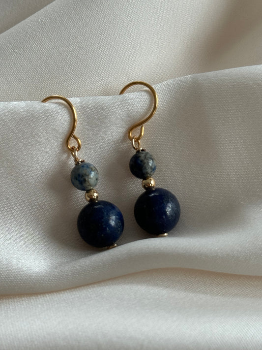 Close-up of round Lapis Lazuli stones with gold earring hooks