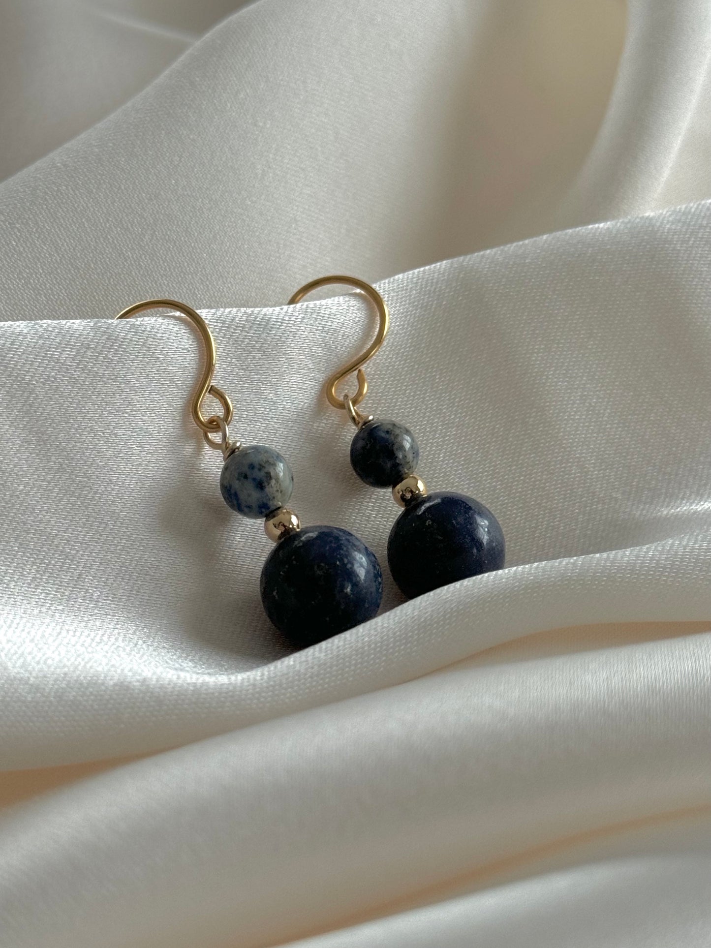 Lapis Lazuli drop earrings resting on natural fabric