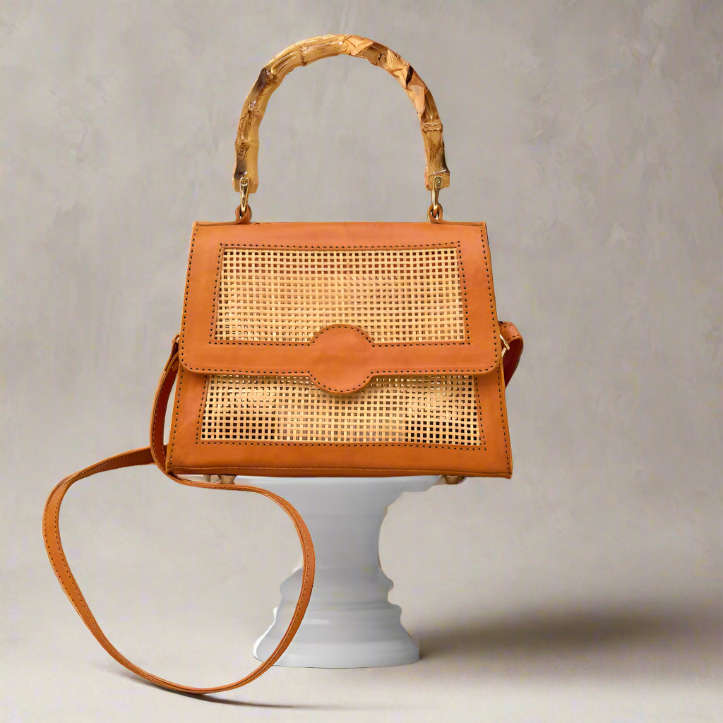 Close up of Maya Rattan Bag with bamboo handle being displayed on a podium.