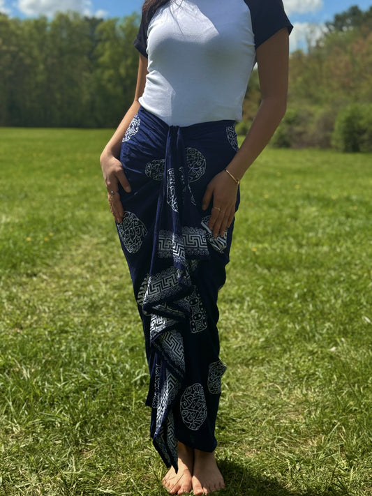 Model wearing navy Sari Sarong Skirt with white traditional prints, standing barefoot on grass.