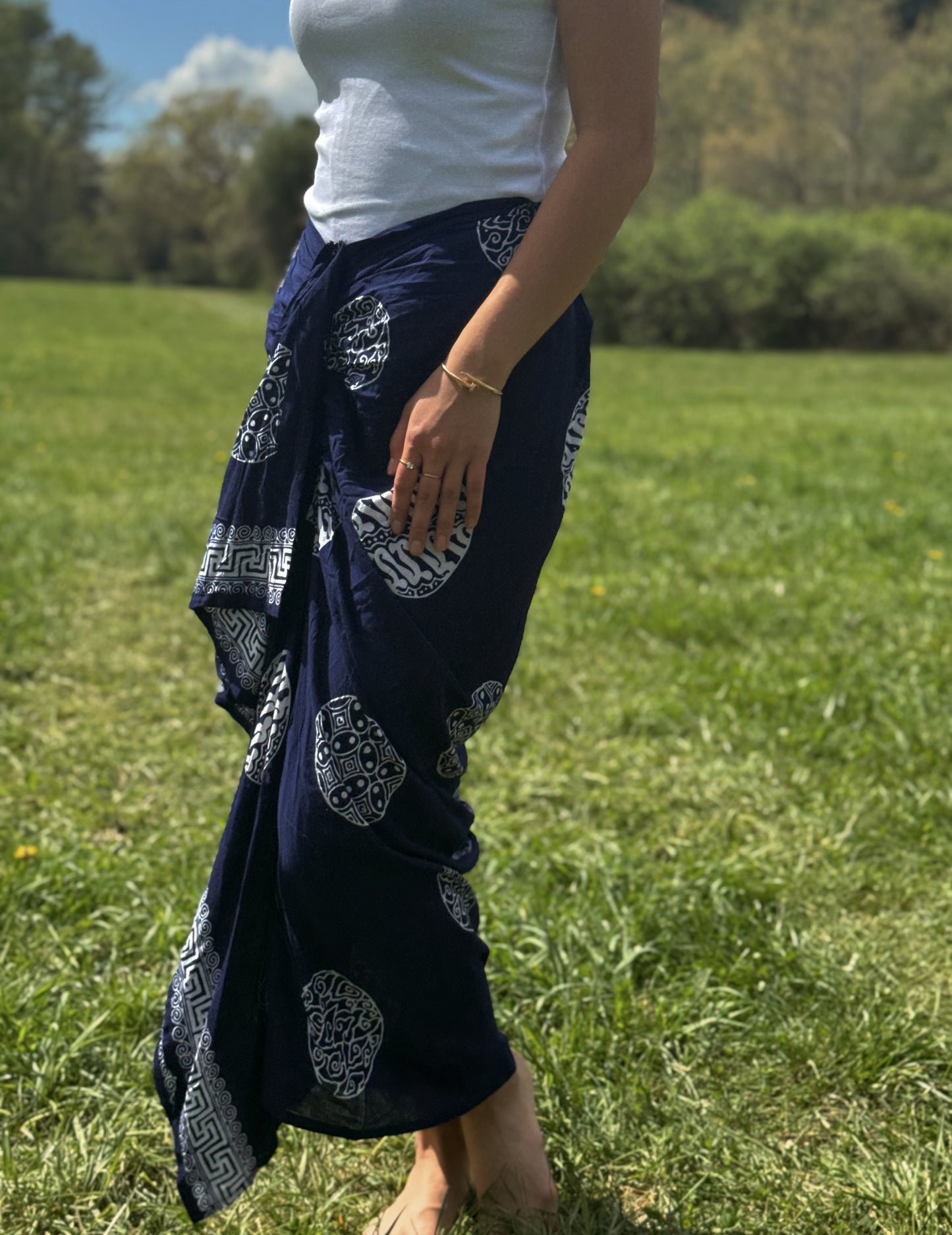 Movement photo of a model wearing navy Sari Sarong Skirt twirling in the grass