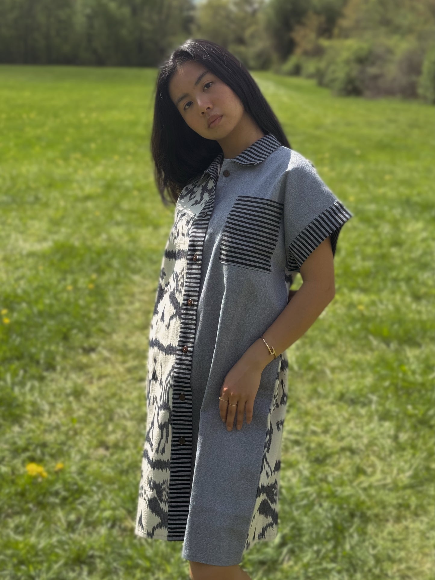 Model posing in Tenun Dress Shirt in grassy field.
