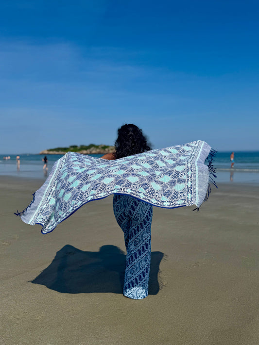 Blue batik scarf displayed by the ocean