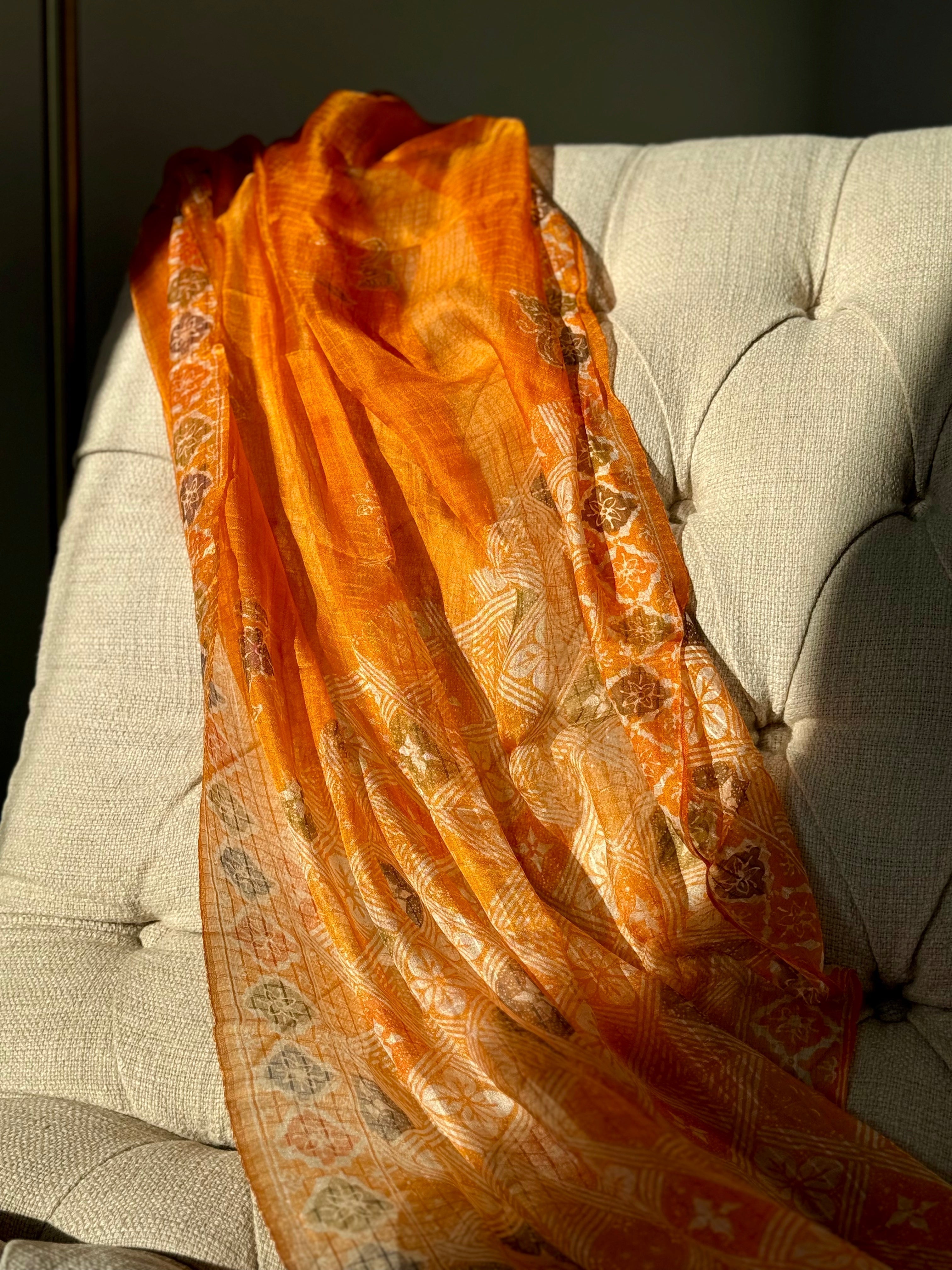Orange Silk Scarf draped over chair, glossy and luxurious