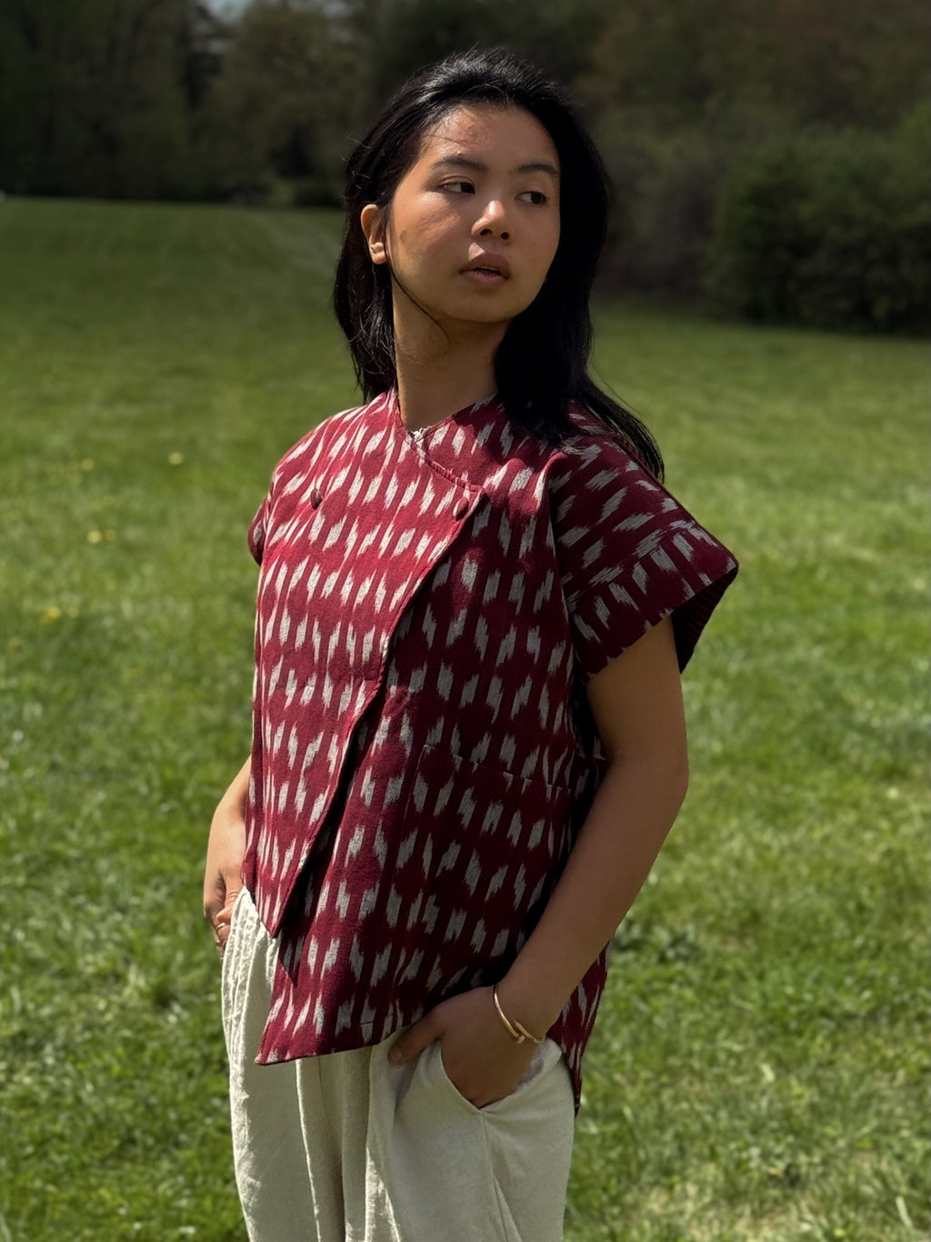 Model wearing Adelia Top standing in a grassy field