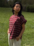 Model wearing Adelia Top standing in a grassy field