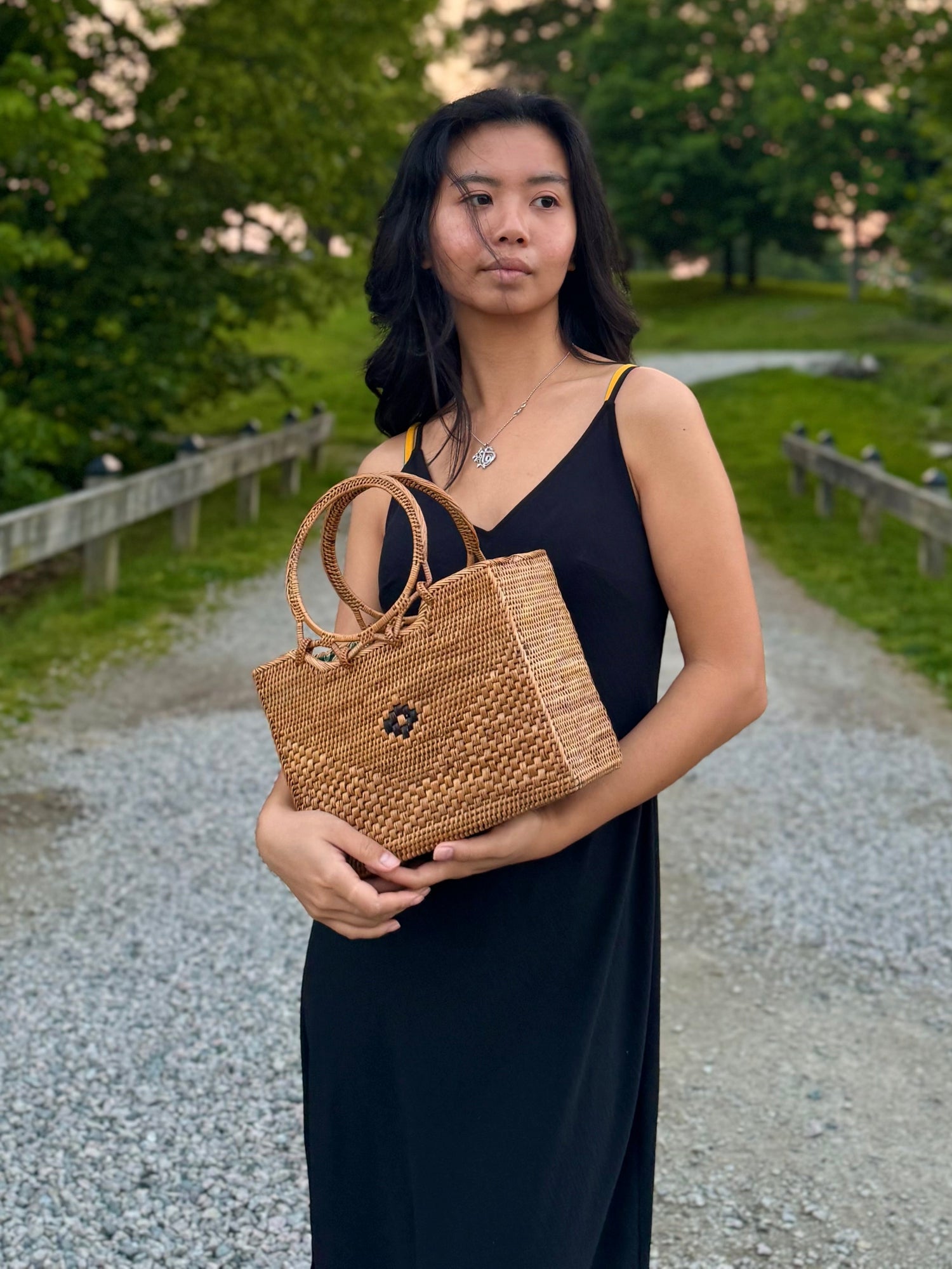 Model holding an Ata Vine Rattan Bag