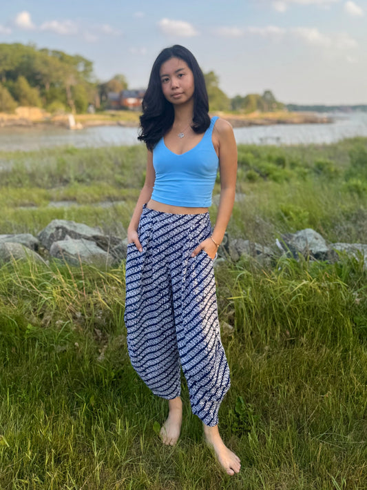 Model wearing Dewi Yoga Pants in Black standing in a grassy field