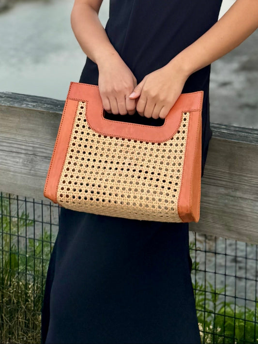 Model wearing a Fitri clutch rattan cane bag.