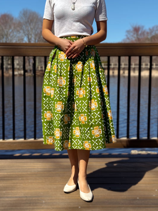 Model wearing Taylor A-Line Knee Length Skirt in green with yellow flower patterns.