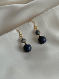 Lapis Lazuli drop earrings resting on natural fabric