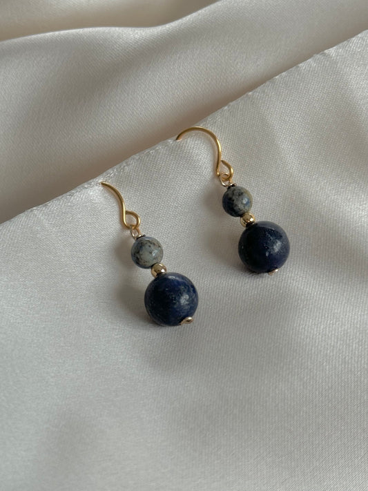 Lapis Lazuli drop earrings resting on natural fabric