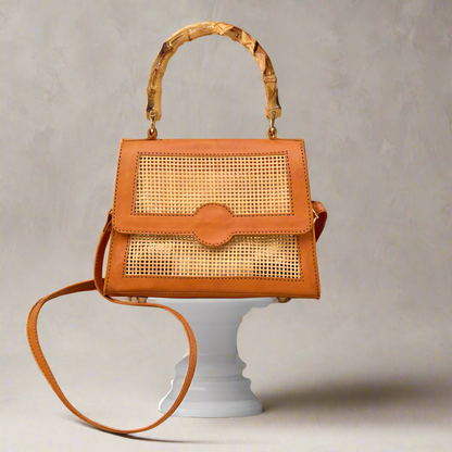 Close up of Maya Rattan Bag with bamboo handle being displayed on a podium.