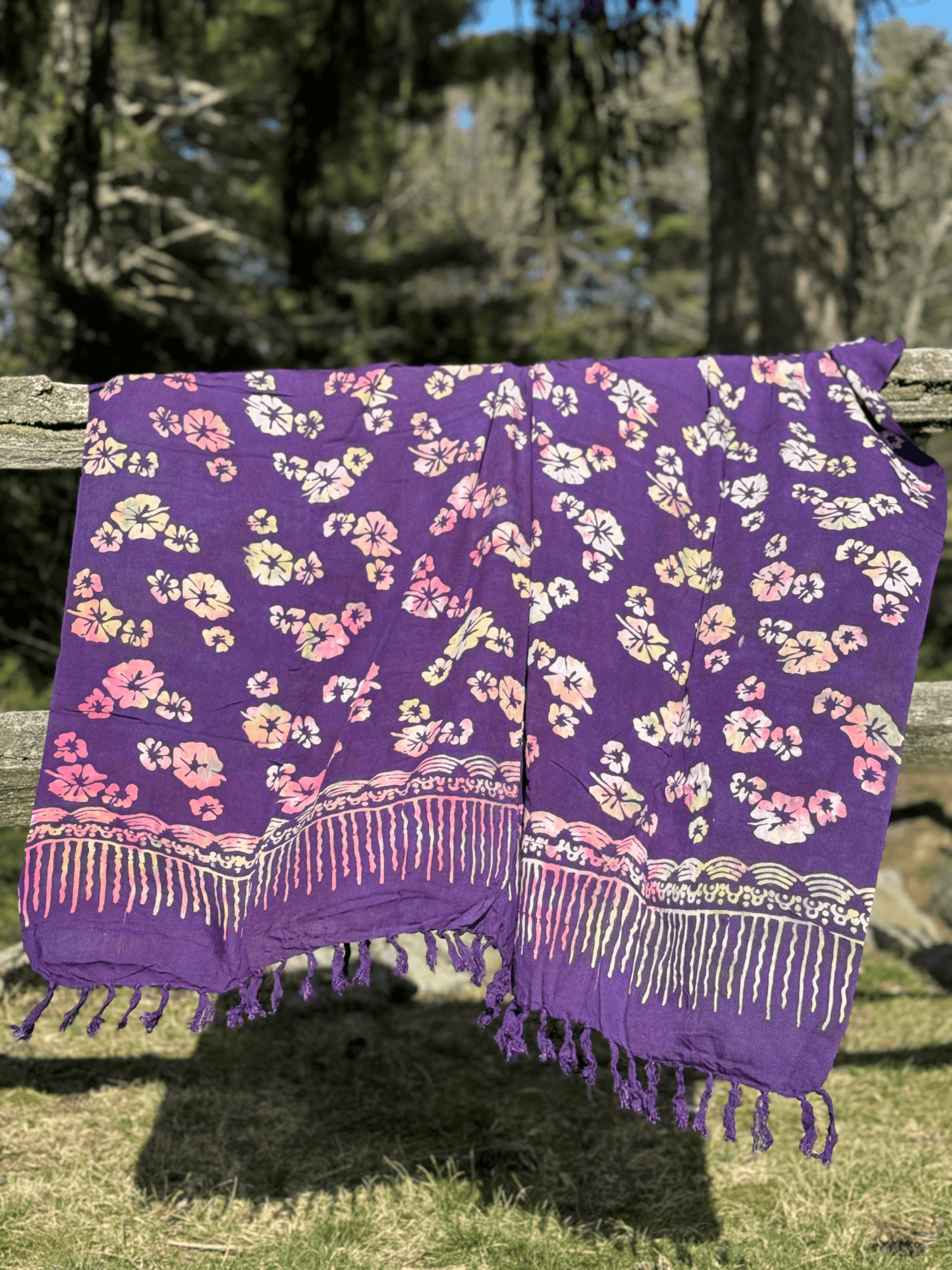 purple bali sarong with flower patterns draped over a fence | Mutiara Heritage