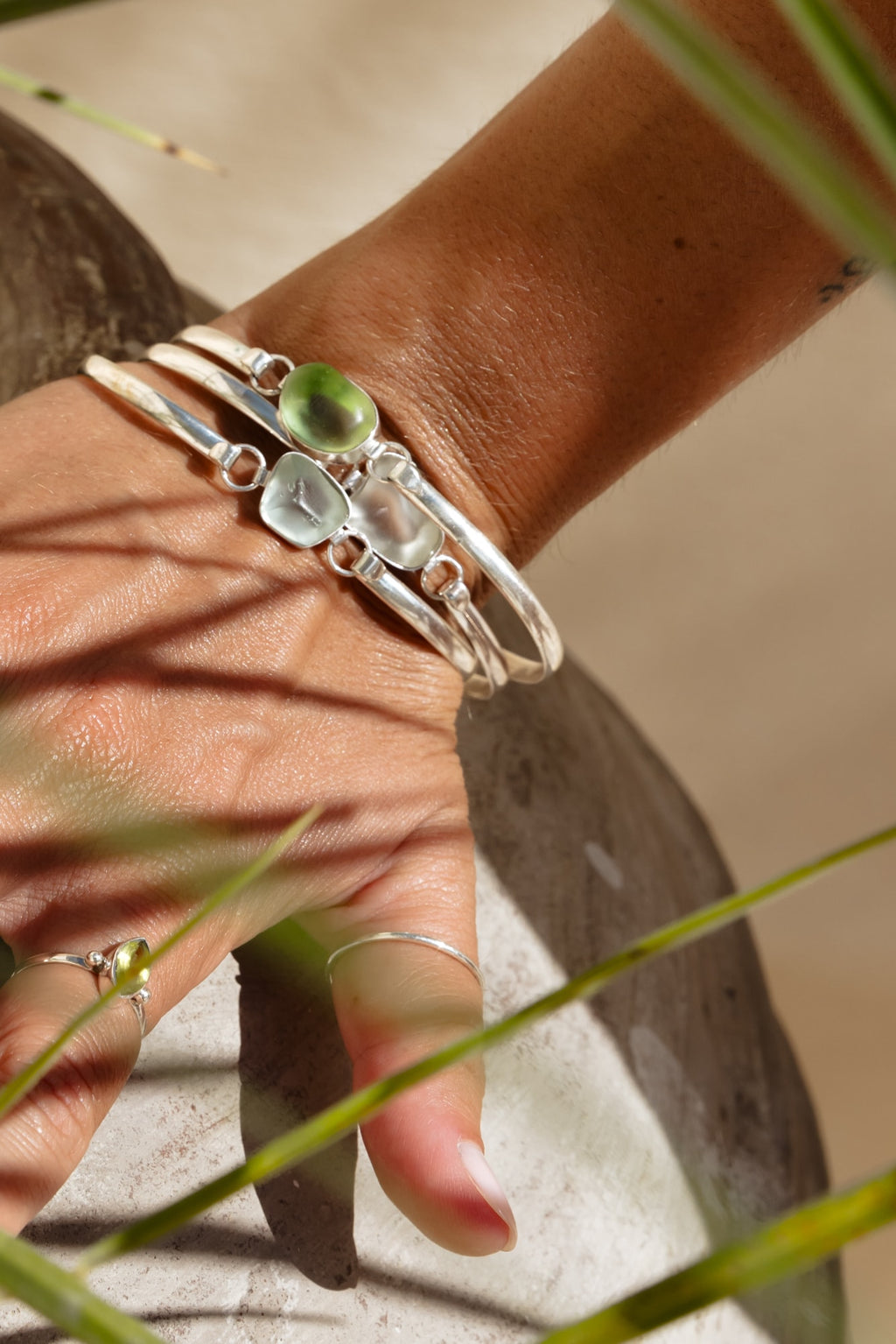 Seaglass bracelet stacked and modeled on a model's wrist with grass decor.