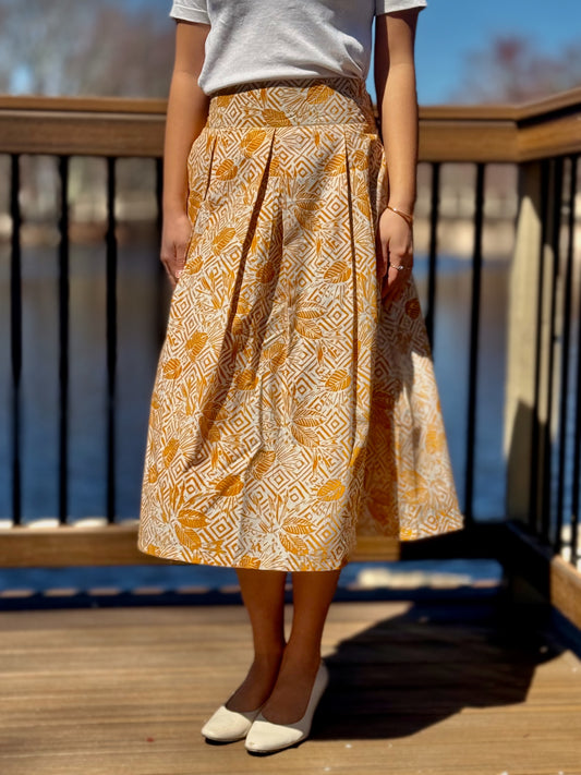 Close up of Taylor A-line skirt in yellow with palm leaves and geometric design. 