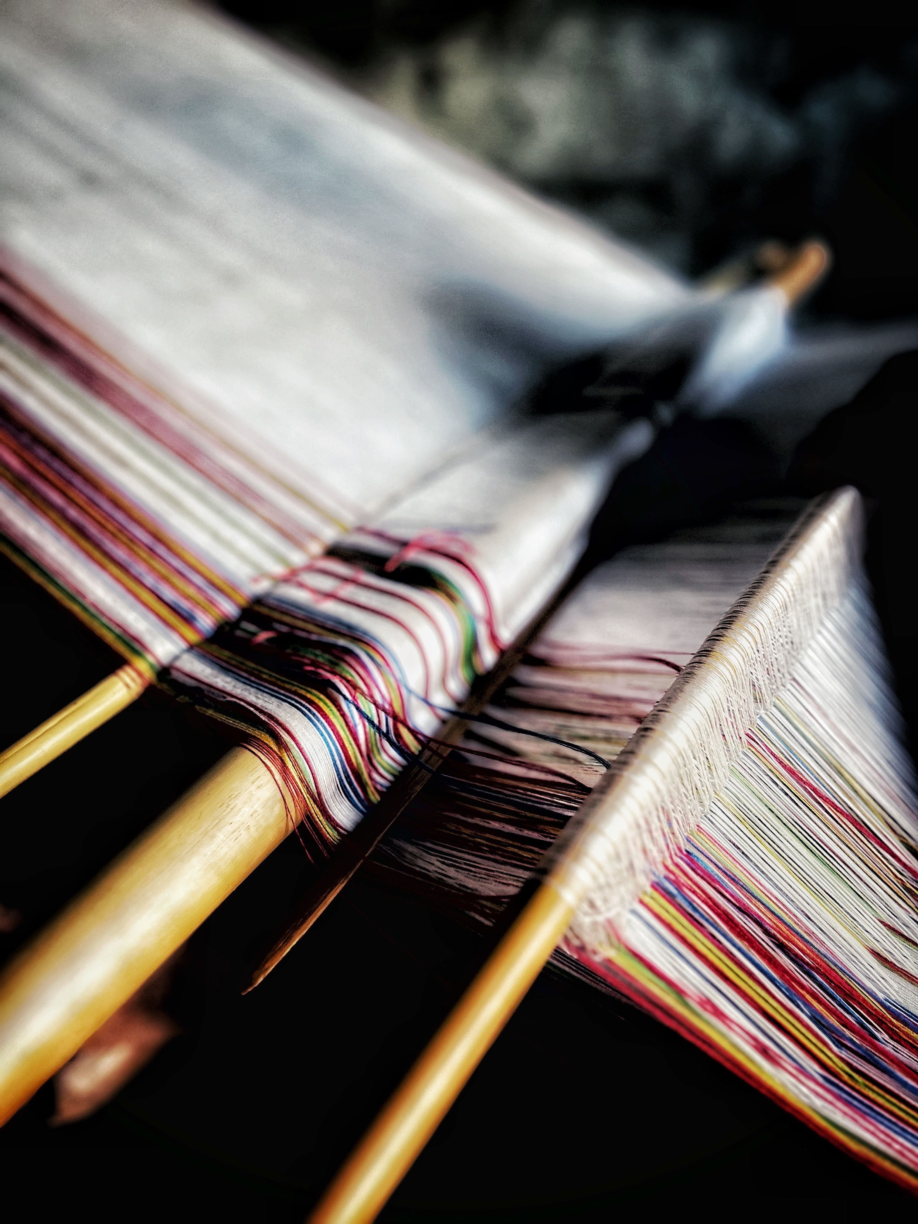 Close-up of a colorful fabric on a loom with a blurred background